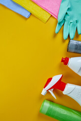 Flat lay of variety house cleaning product on yellow table with copy space
