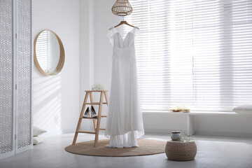 Beautiful wedding dress, shoes and flowers in room