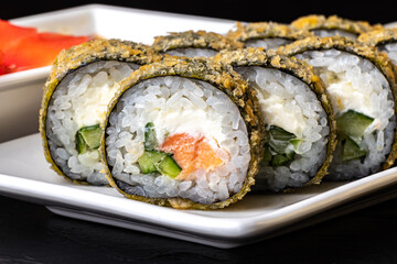 Sushi roll with tuna and cucumber on a white plate close-up. Traditional Japanese cuisine