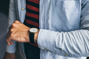 fashionable wearing stylish looking at luxury watch on hand check the time at workplace.concept for...