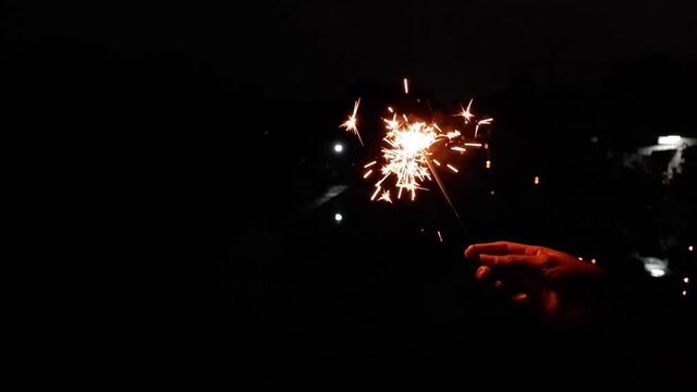Slow video clip of a yellow scab splashing from fireworks in hand  and  black background.