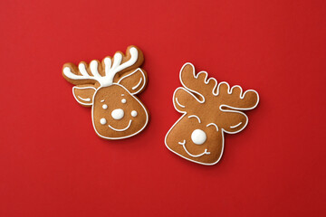 Christmas deer shaped gingerbread cookies on red background, flat lay