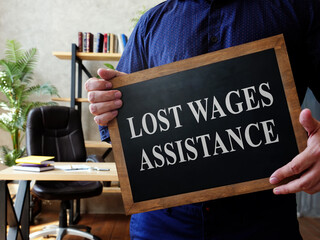 Man holds Lost Wages Assistance plate in the office.