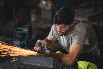 A mechanic wearing safety equipment and operating angle grinder - Metal factory - Industry concept