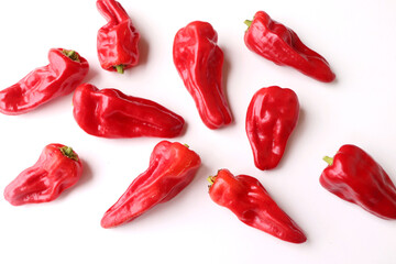Red pimiento de Padron peppers isolated on white background. The peppers are customarily fried in olive oil until the skin starts to blister and the pepper collapses. They are then served with the oil