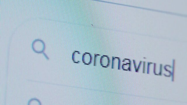 The CORONAVIRUS is written in the search bar using the cursor and the magnifying glass symbol. Macro photography of the monitor display.