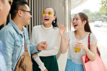 Beautiful young Asian women laughing at jokes of their friend