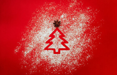Flour scattered in the shape of Christmas tree on red background with star anise. New year banner design for recipes, bakery or pastry shop