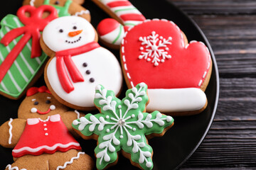 Delicious Christmas cookies on black wooden table table, closeup