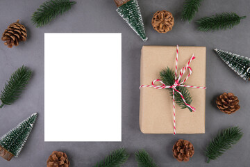 Christmas holiday composition with gift box decoration and greeting card, new year and xmas or anniversary with presents and postcard on cement floor background, top view or flat lay, copy space.