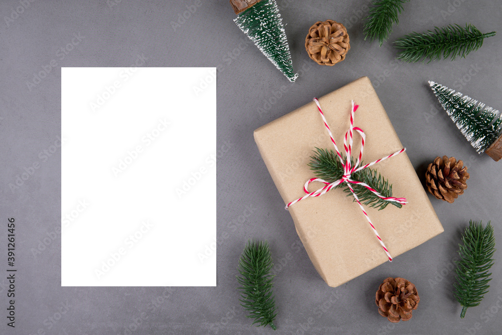 Wall mural Christmas holiday composition with gift box decoration and greeting card, new year and xmas or anniversary with presents and postcard on cement floor background, top view or flat lay, copy space.