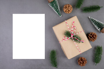 Christmas holiday composition with gift box decoration and greeting card, new year and xmas or anniversary with presents and postcard on cement floor background, top view or flat lay, copy space.