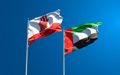 Beautiful national state flags of Gibraltar and UAE United Arab Emirates together at the sky background. 3D artwork concept.