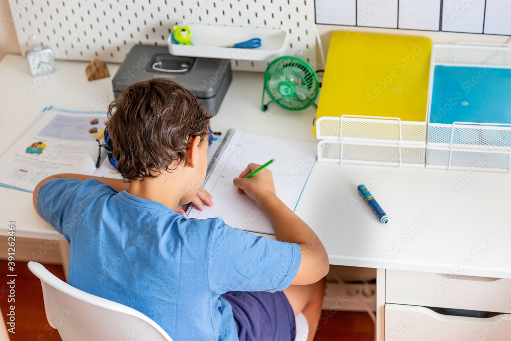 Wall mural Boy sitting at desk doing homework  in his bedroom