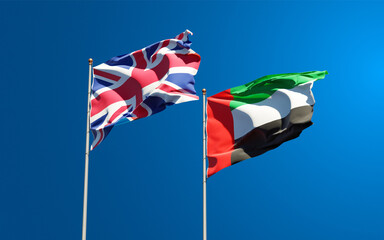 Beautiful national state flags of UK and UAE United Arab Emirates together at the sky background. 3D artwork concept.