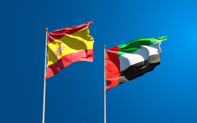 Beautiful national state flags of Spain and UAE United Arab Emirates together at the sky background. 3D artwork concept.