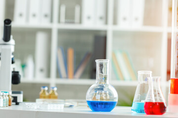 Microscope on the table with glassware in laboratory