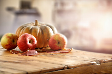 Autumn fruits on a wooden table surrounded by the setting sun