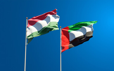 Beautiful national state flags of Hungary and UAE United Arab Emirates together at the sky background. 3D artwork concept.