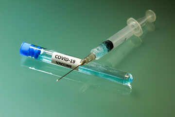 Syringe next to test tube with Covid-19 vaccine
