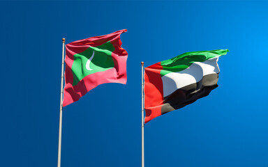 Beautiful national state flags of Maldives and UAE United Arab Emirates together at the sky background. 3D artwork concept.