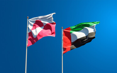 Beautiful national state flags of Greenland and UAE United Arab Emirates together at the sky background. 3D artwork concept.