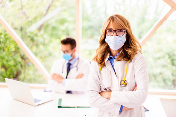 Female doctor wearing face mask while standing at doctor's office