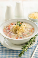 Vegetable soup with cheese and fresh herbs.