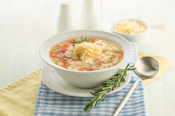 Vegetable soup with cheese and fresh herbs.