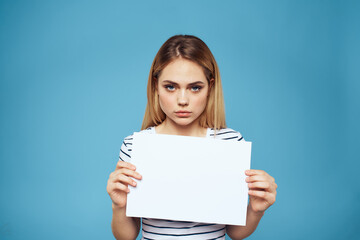 Fototapeta premium Emotional woman holding a sheet of paper in her hands lifestyle close-up blue background Copy Space