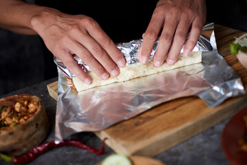 man wrapping a durum or a burrito