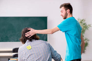 Obraz premium Two male pupils in bullying concept in the classroom