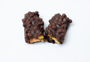 Broken pieces of nuts and milk chocolate bar isolated on white background