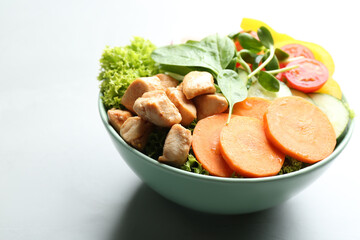 Delicious fresh chicken salad served on grey table, closeup