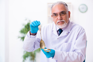 Old senior archaeologist working in the lab