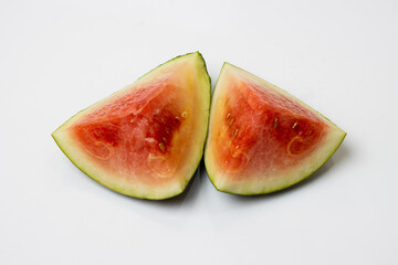 Two pieces of sliced organic watermelon on a white background