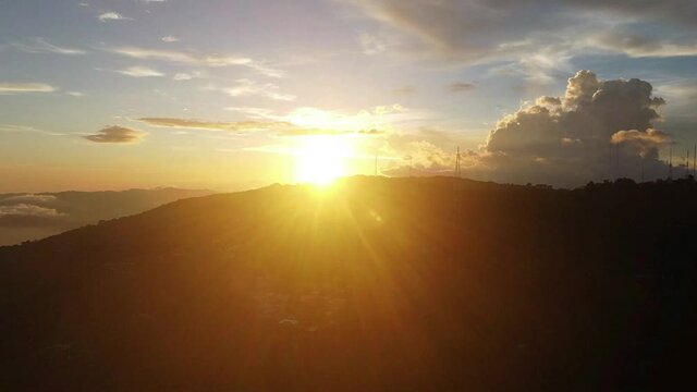 Bright Golden Sunset Hiding In The Mountains From Boqueron Volcano In San Salvador, El Salvador. - aerial descend