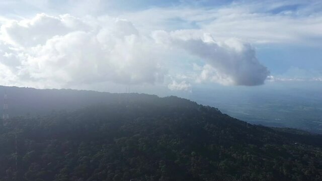 Fluffy Clouds Above Misty Mountain In El Boqueron Park, El Salvador - aerial panning shot