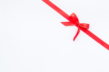 Red ribbon bow on white background, top view, copy space