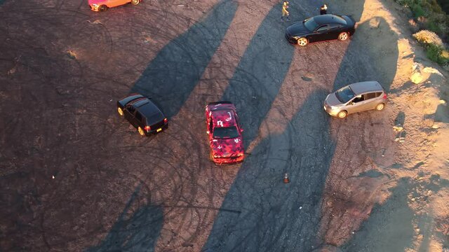Done shot of a Dodge Challenger with muscle and sports cars doing doughnuts and burnouts with a car club in the Angeles National Forest in Southern California