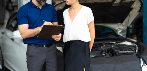 Car insurance concept. Insurance Agent examine Damaged Car with woman customer write information on...