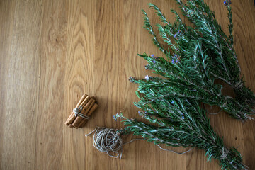 Rosemary bounds on wooden table. Aromatic plant top view photo. Healing herbs close up. 
