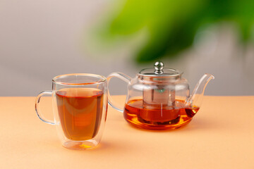 Glass teapot and cup with black tea