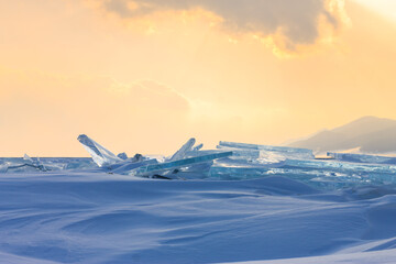 Transparent blue hummocks Baikal ice is shining through the crack sunset
