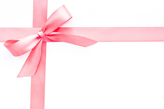 Pink ribbon with bow isolated on white for gift box. Top view, copy space