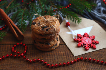 Cozy winter home background. Cookies with chocolate, cinnamon, envelope and Christmas tree. Festive, holiday Christmas concept. Close-up, selective focus