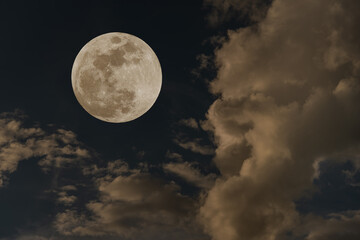 Obraz na płótnie Canvas Full moon over clouds on the sky.