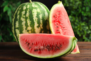 Whole and cut ripe watermelons on wooden table