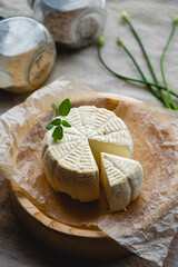 White cheese on a wooden board with olive oil on a brown background.