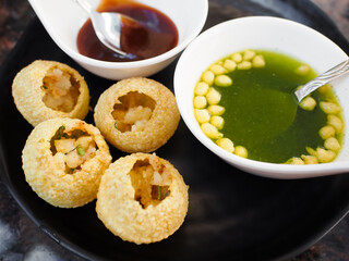 Panipuri, famous street food in Pakistan, India and Bangladesh. Other names are fuchka, gupchup or...